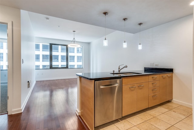 1200 Main St Unit 707, Dallas, TX 75202 - kitchen featuring stainless steel dishwasher, a sink, dark countertops, baseboards, and pendant lighting