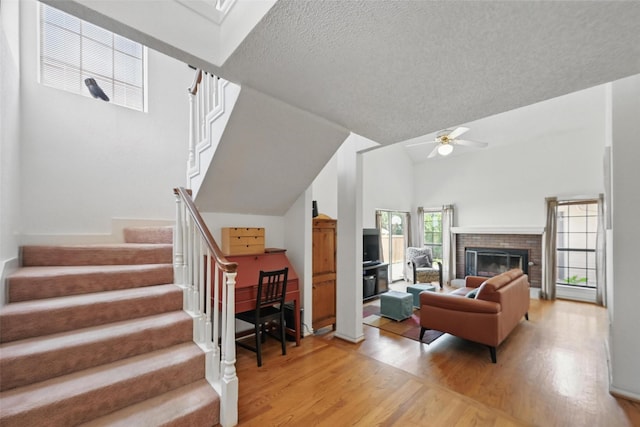 2708 Van Gogh Pl, Dallas, TX 75287 - living area with light wood-type flooring, ceiling fan, stairway, lofted ceiling, and a brick fireplace