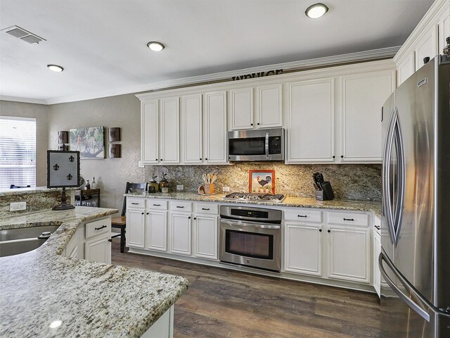 7425 Quiet Meadow Ln, Frisco, TX 75033 - kitchen with appliances with stainless steel finishes, dark wood-style floors, white cabinetry, tasteful backsplash, and crown molding