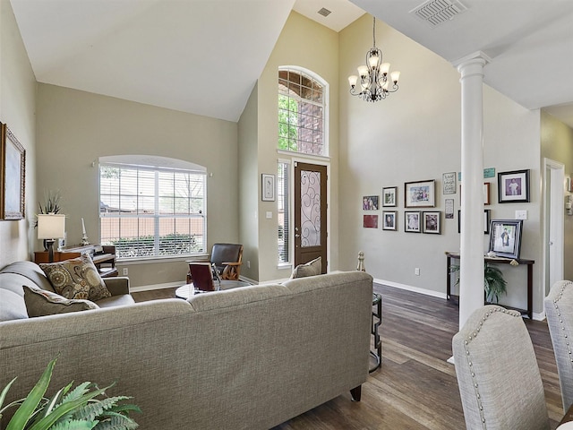 7425 Quiet Meadow Ln, Frisco, TX 75033 - living area with decorative columns, dark wood-style flooring, high vaulted ceiling, baseboards, and a chandelier