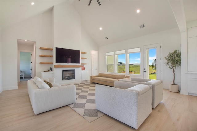 1339 Malone Dr, Royse City, TX 75189 - living room with high vaulted ceiling, a glass covered fireplace, recessed lighting, light wood finished floors, and baseboards