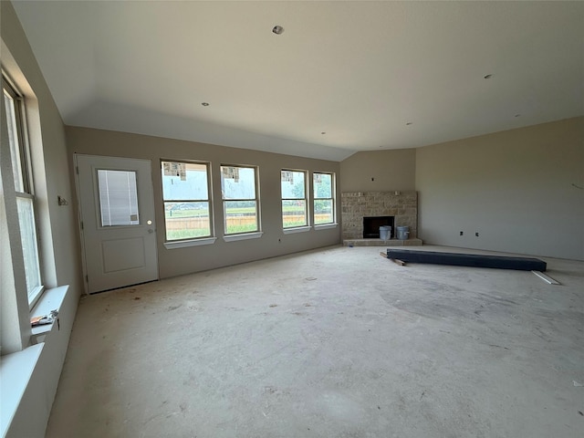 436 Guadalupe Trl, Springtown, TX 76087 - unfurnished living room featuring vaulted ceiling, unfinished concrete floors, and a fireplace with raised hearth