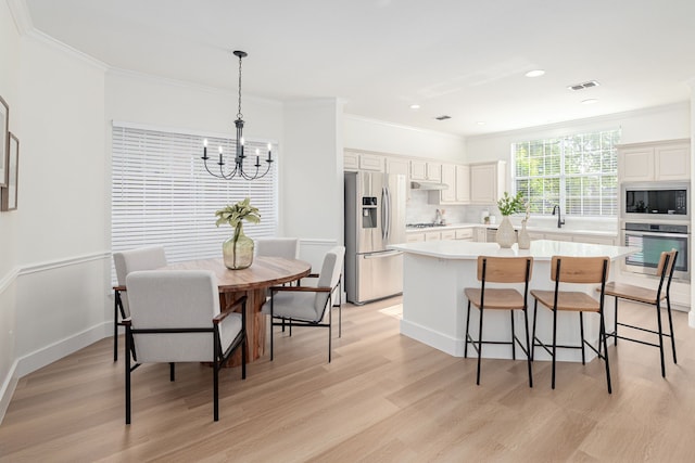 7901 Cross Plains Dr, Plano, TX 75025 - kitchen featuring stainless steel appliances, a chandelier, light countertops, crown molding, and a breakfast bar