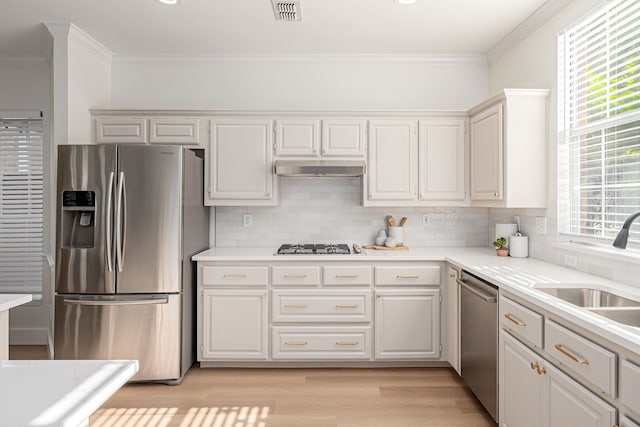 7901 Cross Plains Dr, Plano, TX 75025 - kitchen featuring appliances with stainless steel finishes, crown molding, a sink, backsplash, and light countertops