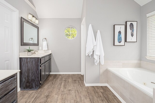 7901 Cross Plains Dr, Plano, TX 75025 - bathroom featuring wood finished floors, vanity, a garden tub, baseboards, and lofted ceiling