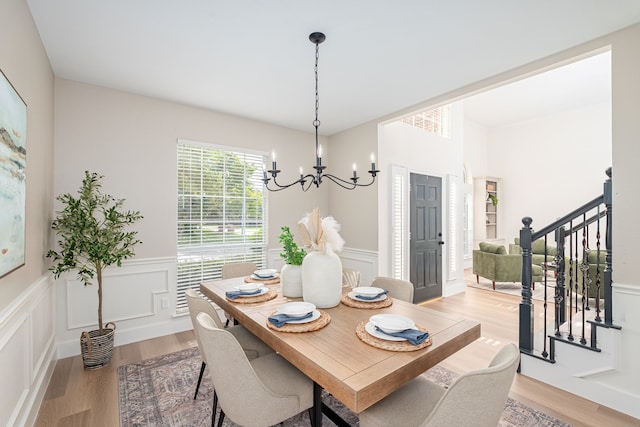 7901 Cross Plains Dr, Plano, TX 75025 - dining area featuring a chandelier, light wood-type flooring, stairway, wainscoting, and a decorative wall
