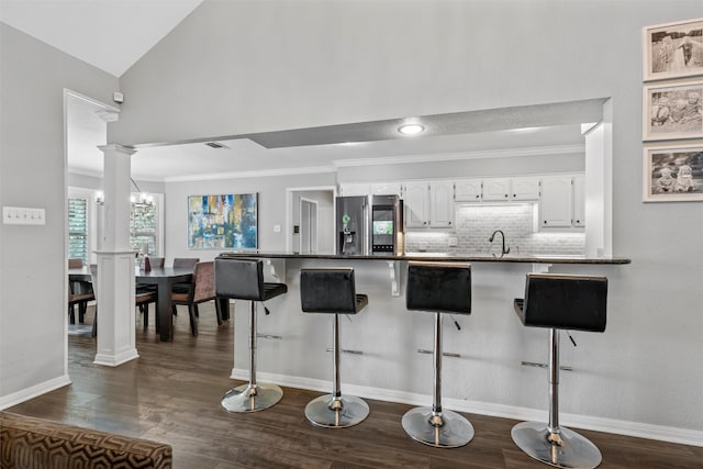 7125 Fish Pond Rd, Waco, TX 76710 - kitchen with stainless steel refrigerator with ice dispenser, white cabinetry, a breakfast bar, a peninsula, and tasteful backsplash
