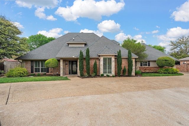 7125 Fish Pond Rd, Waco, TX 76710 - view of front of house featuring roof with shingles, brick siding, driveway, and fence