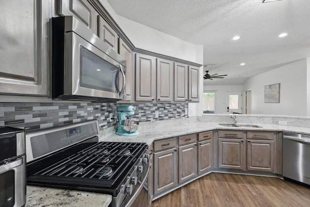 1010 Greenbriar Ln, Mckinney, TX 75069 - kitchen with appliances with stainless steel finishes, a sink, dark wood finished floors, ceiling fan, and tasteful backsplash