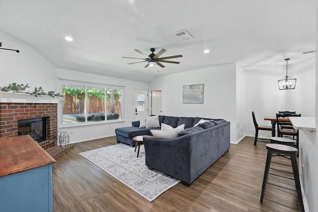 1010 Greenbriar Ln, Mckinney, TX 75069 - living room with vaulted ceiling, dark wood-style floors, a brick fireplace, a ceiling fan, and recessed lighting