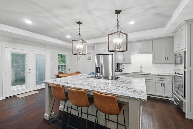3713 Collinwood Ave, Fort Worth, TX 76107 - kitchen featuring stainless steel appliances, a sink, decorative backsplash, a chandelier, and dark wood-style floors