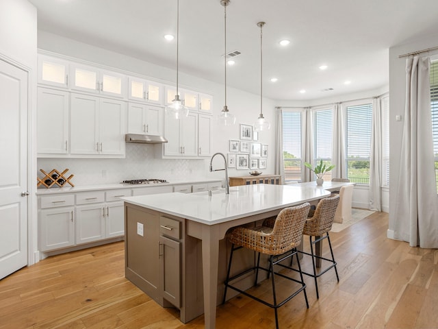 317 Legna Dr, Aledo, TX 76008 - kitchen with a sink, gas stovetop, light countertops, backsplash, and an island with sink