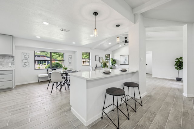 101 Oakmont Dr, Trophy Club, TX 76262 - kitchen with wood tiled floors, ceiling fan, a breakfast bar, light countertops, and recessed lighting