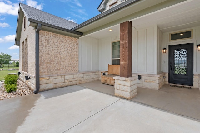 3304 Cobbler Ln, Joshua, TX 76058 - doorway to property featuring board and batten siding, a shingled roof, brick siding, and a porch