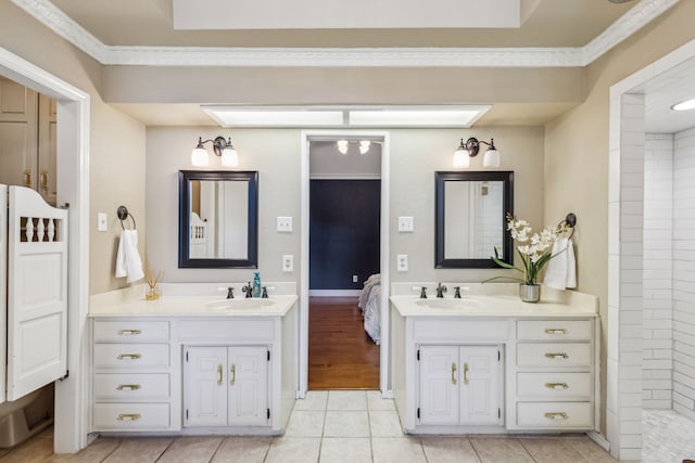 bathroom featuring two vanities, tile patterned flooring, ornamental molding, and tiled shower