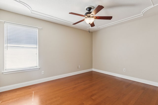 spare room with wood finished floors, baseboards, and a ceiling fan