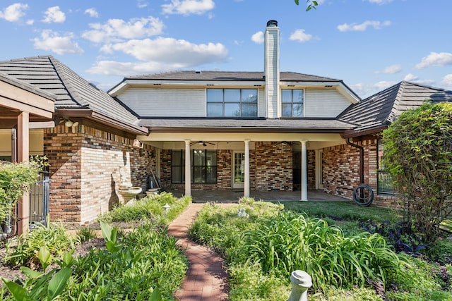 back of house featuring brick siding, fence, and a ceiling fan