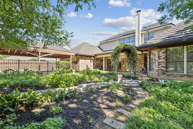 rear view of house with brick siding and fence