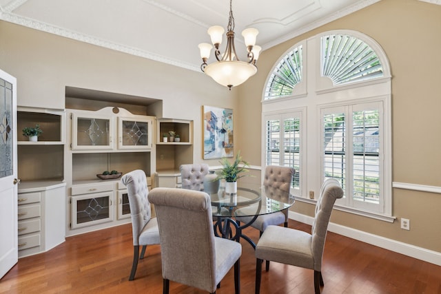 dining area featuring healthy amount of natural light, wood finished floors, a chandelier, crown molding, and baseboards