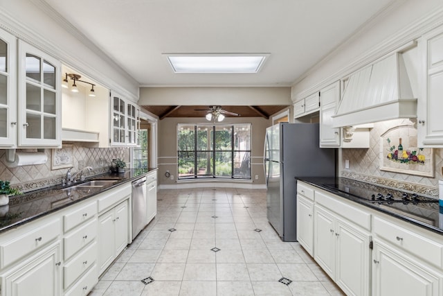 kitchen with a sink, appliances with stainless steel finishes, custom exhaust hood, white cabinetry, and ornamental molding