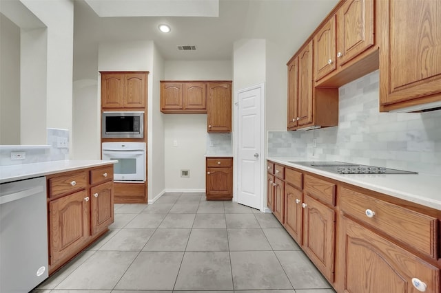 kitchen featuring white oven, dishwashing machine, stainless steel microwave, black electric stovetop, and decorative backsplash