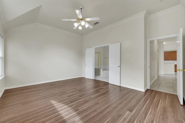 unfurnished bedroom with wood finished floors, crown molding, baseboards, connected bathroom, and ceiling fan