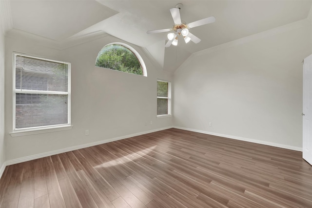 spare room featuring a ceiling fan, wood finished floors, baseboards, lofted ceiling, and crown molding