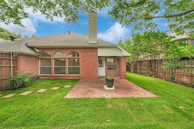 back of house with brick siding, a chimney, a patio area, and roof with shingles