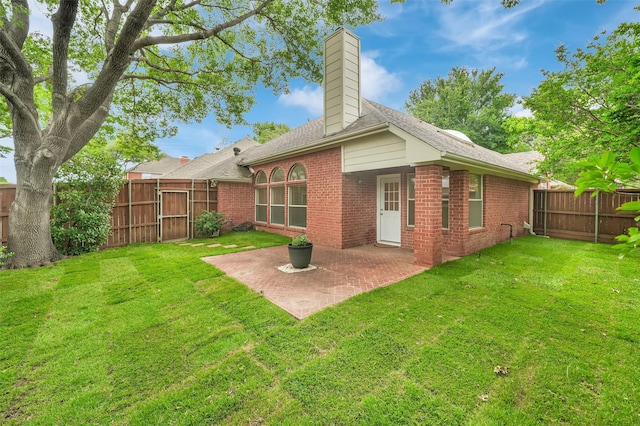 back of property with brick siding, a chimney, and a patio area