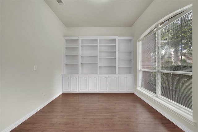 spare room with dark wood-type flooring and baseboards