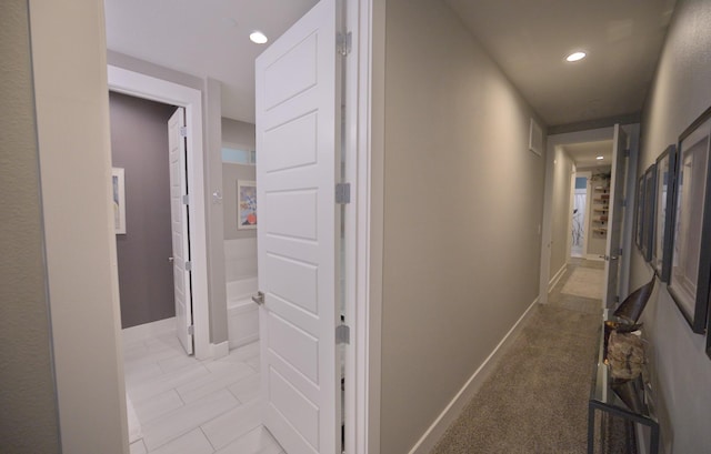hallway featuring recessed lighting and baseboards