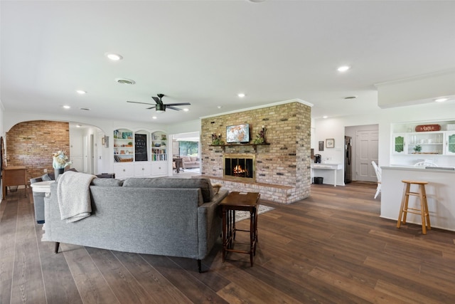 2173 Fairway Acres Dr, Argyle, TX 76226 - living area with arched walkways, a fireplace, a ceiling fan, dark wood finished floors, and recessed lighting