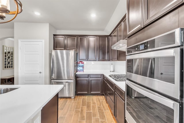 2125 Swanmore Way, Forney, TX 75126 - kitchen with stainless steel appliances, light countertops, dark brown cabinetry, light wood-style floors, and recessed lighting