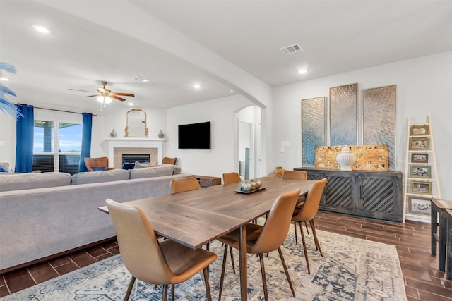 2125 Swanmore Way, Forney, TX 75126 - dining room with wood finish floors, arched walkways, a fireplace, a ceiling fan, and recessed lighting