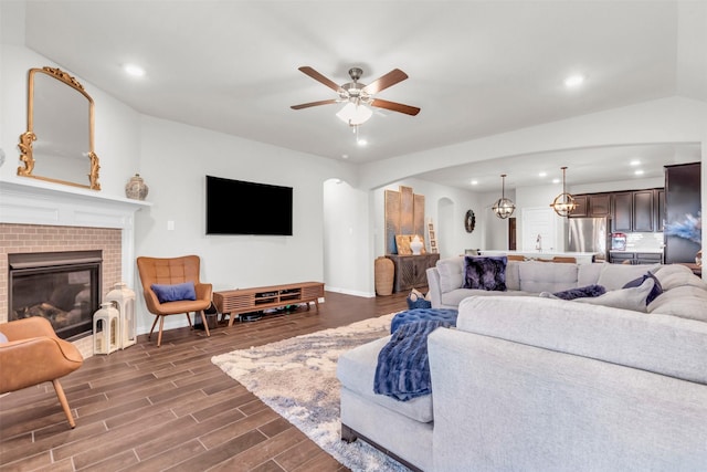 2125 Swanmore Way, Forney, TX 75126 - living room featuring recessed lighting, dark wood finished floors, a ceiling fan, arched walkways, and a brick fireplace