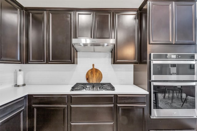 2125 Swanmore Way, Forney, TX 75126 - kitchen with appliances with stainless steel finishes, backsplash, dark brown cabinets, light countertops, and under cabinet range hood