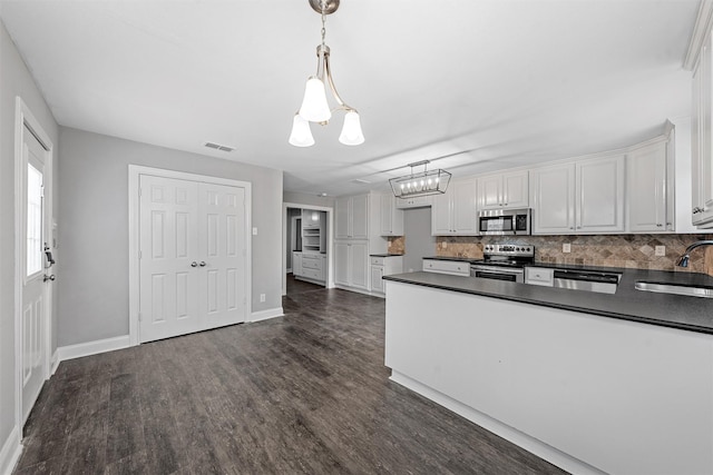 4016 Austin Ave, Waco, TX 76710 - kitchen featuring appliances with stainless steel finishes, a sink, dark countertops, and a chandelier