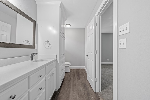4016 Austin Ave, Waco, TX 76710 - bathroom featuring toilet, wood finished floors, baseboards, and vanity