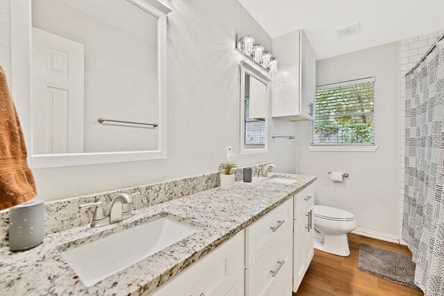 2409 Janice Ln, Fort Worth, TX 76112 - bathroom with toilet, wood finished floors, double vanity, and a shower with curtain