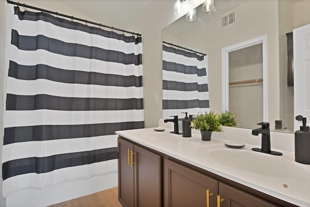 10152 Parker Springs Dr, Waco, TX 76708 - bathroom featuring double vanity, wood finished floors, and a shower with shower curtain