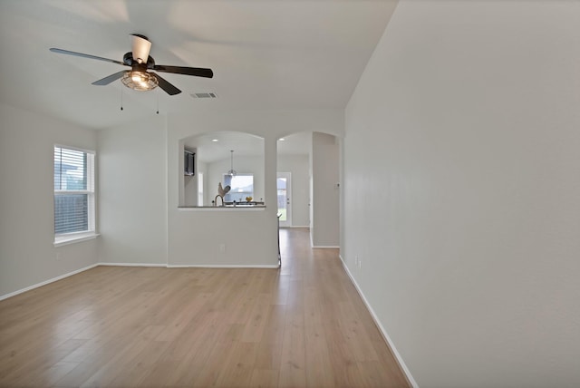 10152 Parker Springs Dr, Waco, TX 76708 - unfurnished living room featuring ceiling fan, light wood-style flooring, arched walkways, and baseboards