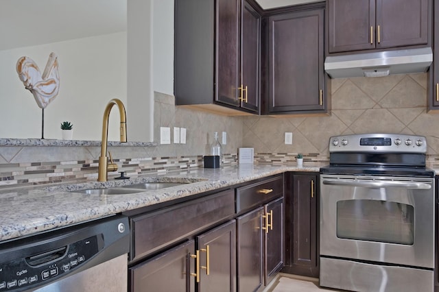10152 Parker Springs Dr, Waco, TX 76708 - kitchen with appliances with stainless steel finishes, a sink, under cabinet range hood, dark brown cabinetry, and light stone counters