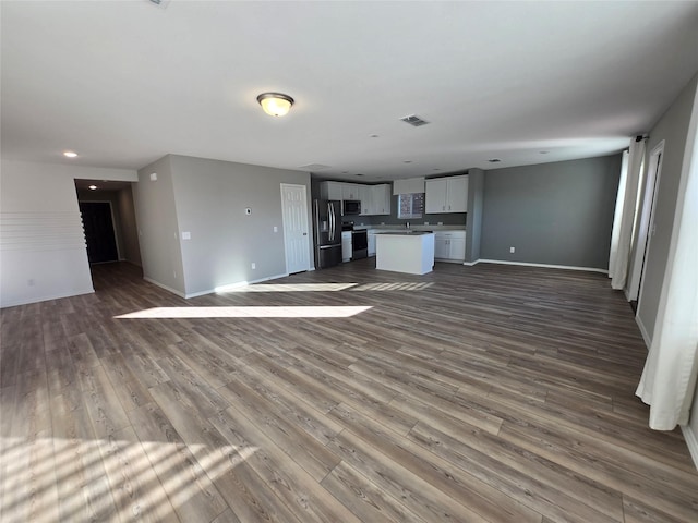 254 Lake Erie Dr, Princeton, TX 75407 - unfurnished living room with baseboards, dark wood finished floors, and recessed lighting