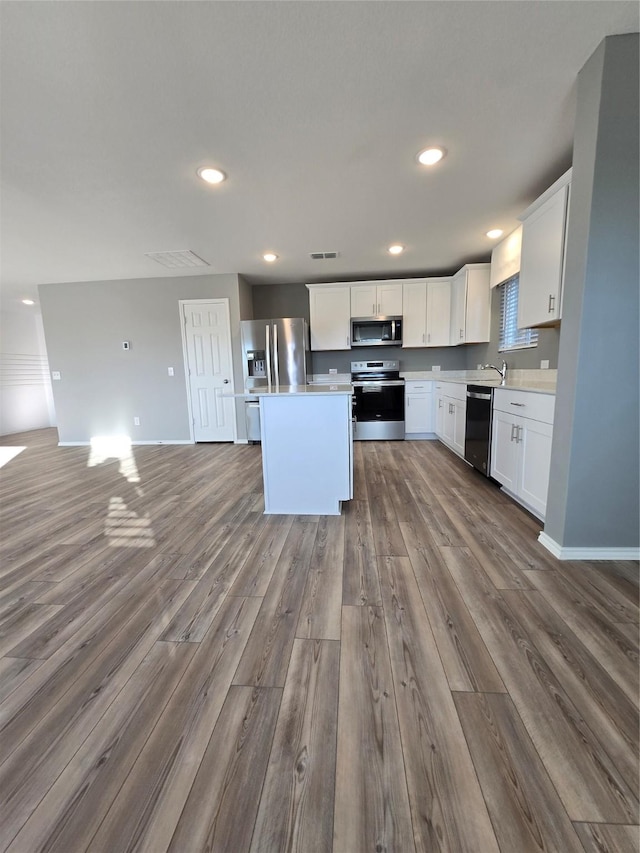 254 Lake Erie Dr, Princeton, TX 75407 - kitchen with appliances with stainless steel finishes, dark wood finished floors, open floor plan, a sink, and light countertops
