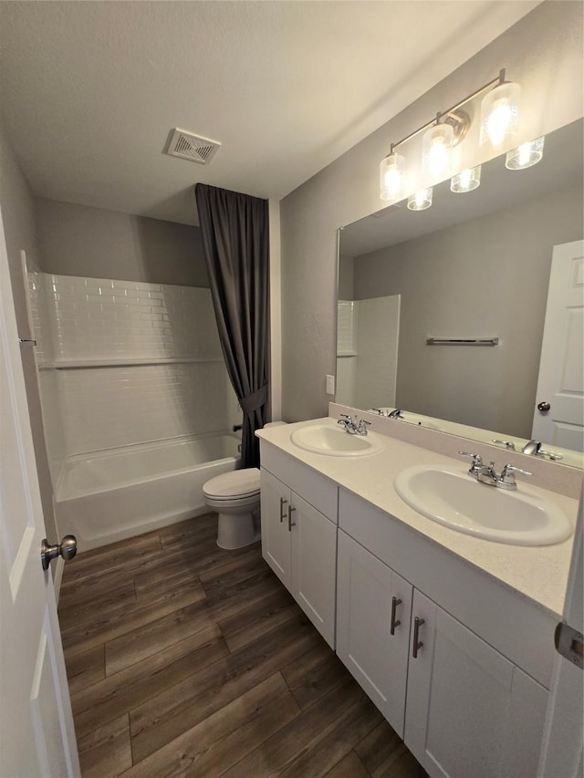 254 Lake Erie Dr, Princeton, TX 75407 - bathroom featuring wood finished floors, double vanity, shower / tub combo with curtain, and toilet