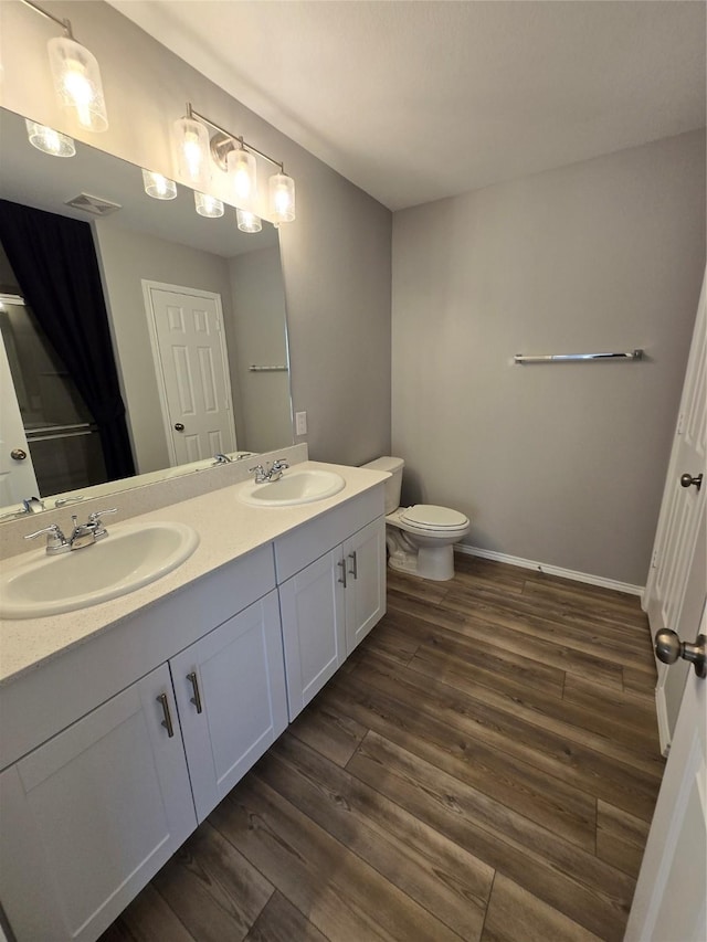 254 Lake Erie Dr, Princeton, TX 75407 - full bath with double vanity, wood finished floors, toilet, and baseboards