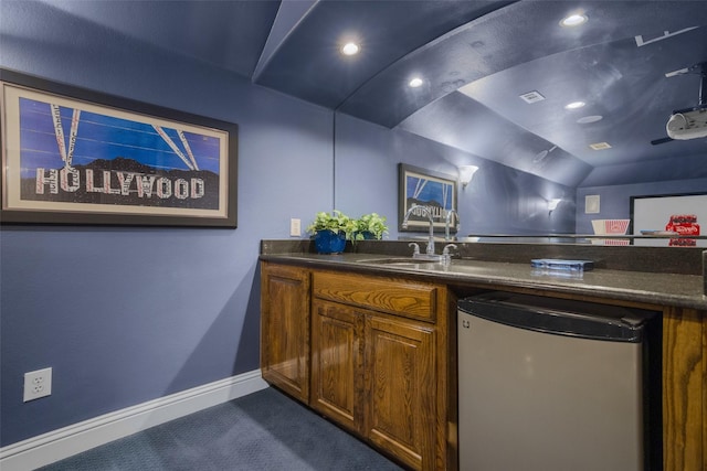 2410 Gail St, Royse City, TX 75189 - kitchen with fridge, dark colored carpet, baseboards, dark countertops, and lofted ceiling