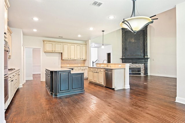 8604 Preston Wood Dr, Mckinney, TX 75072 - kitchen with cream cabinets, appliances with stainless steel finishes, a center island, light countertops, and recessed lighting