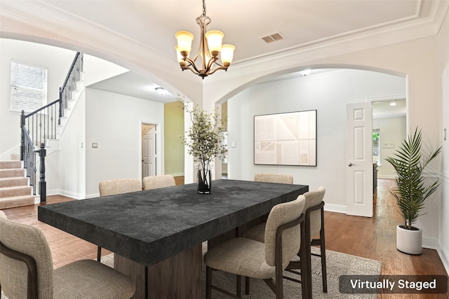 8604 Preston Wood Dr, Mckinney, TX 75072 - dining room featuring arched walkways, a chandelier, wood finished floors, stairs, and baseboards