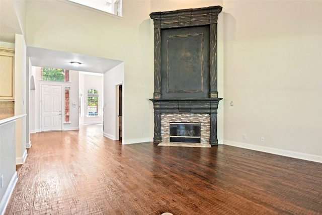 8604 Preston Wood Dr, Mckinney, TX 75072 - unfurnished living room featuring wood finished floors, a brick fireplace, and baseboards
